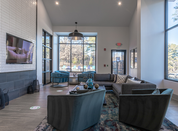 Clubhouse, long sofa, tv, hard wood floors, and chairs.